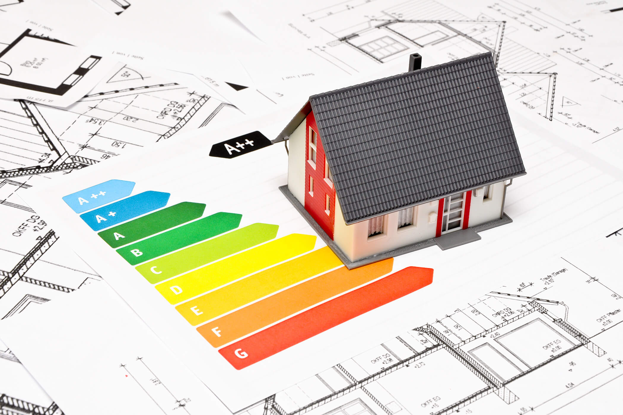 Ein Musterhaus auf den Bauplänen mit einer Energieeffizienzskala von A++ (grün) bis G (rot). - Helplan